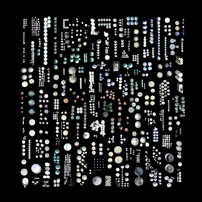 A collection of cutouts of satellite imagery of slightly blue or silver circular buildings, some in dense clusters, against a black backdrop