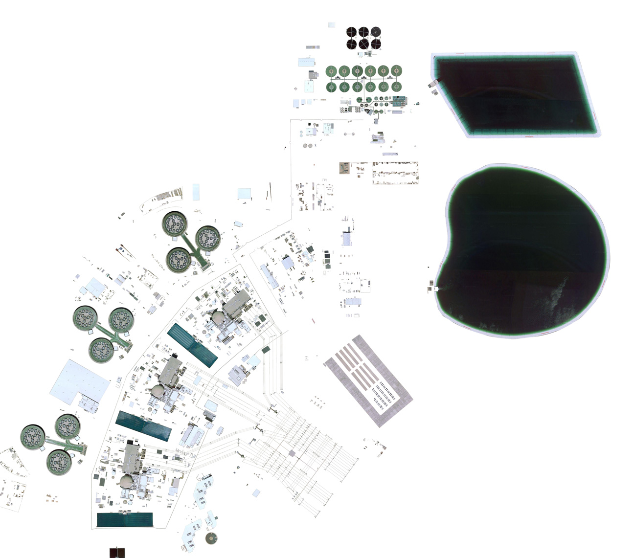 Isolated satellite imagery of a nuclear plant, with buildings, pipes, and a large waste pond