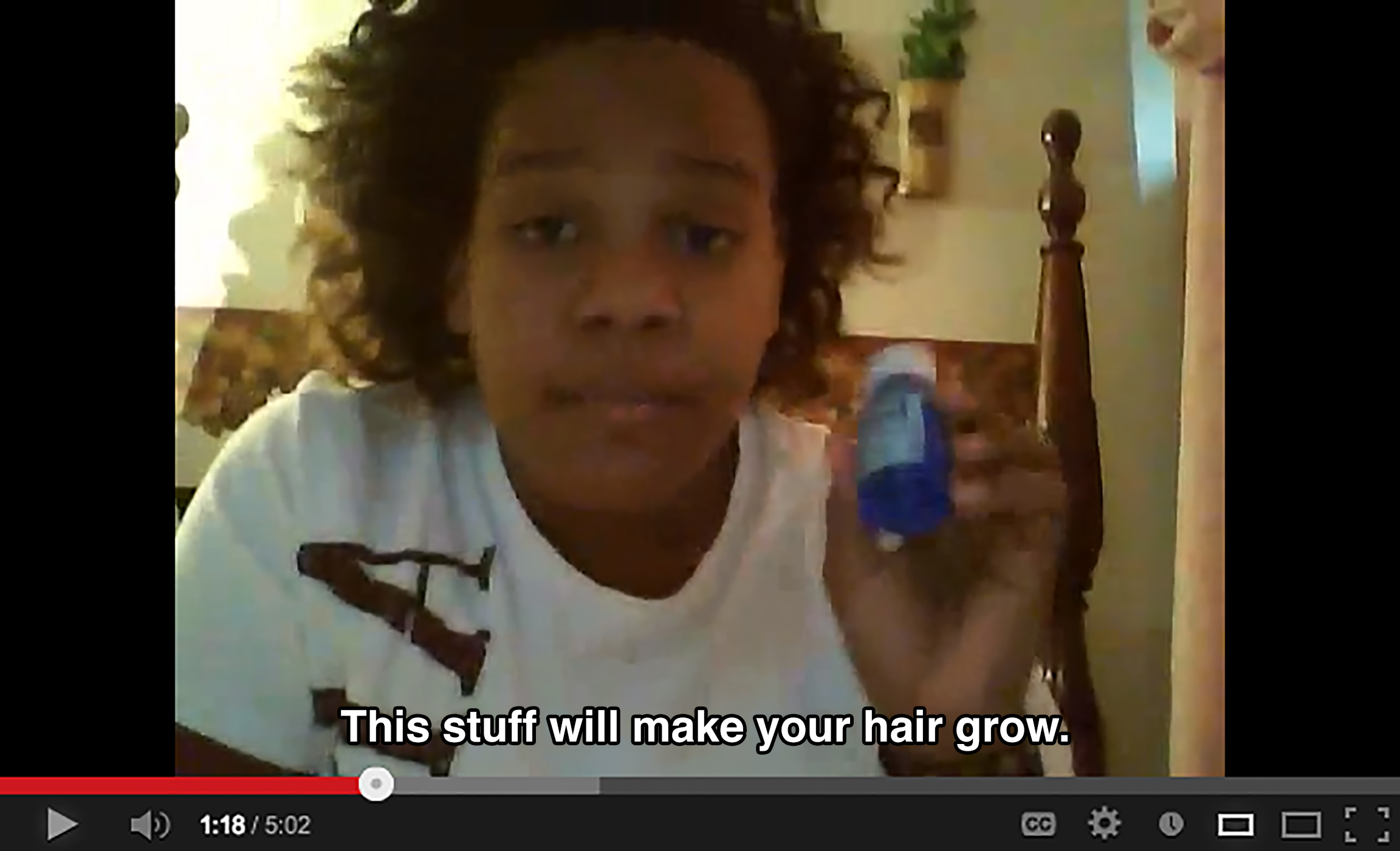 A teenager in a bedroom holds up a small blue container and says: This stuff will make your hair grow.