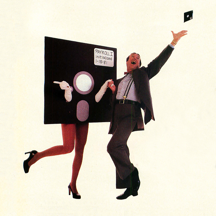 A businessman dancing with a giant floppy disk that has women's legs, while throwing a regular sized floppy disk into the air