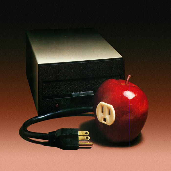 A power system device with a cable next to an apple with an electric outlet