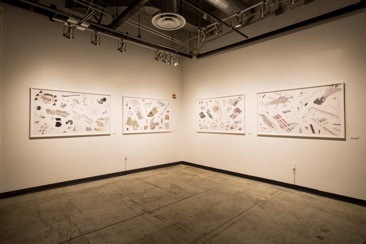 Installation shot of four large framed pieces in a gallery, each showing some of the images described above, but grouped into four categories: power, waste, manufacturing, and transportation.